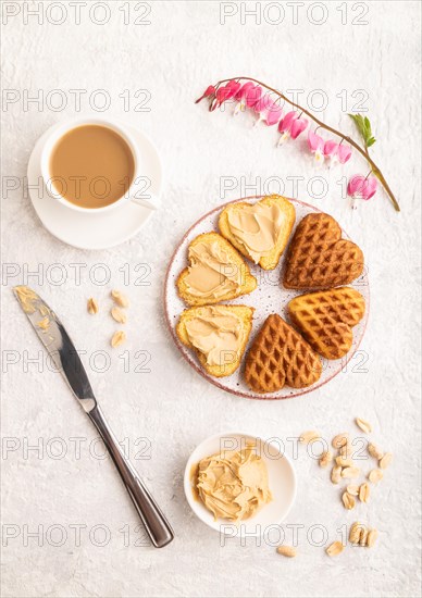 Homemade waffle with peanut butter and cup of coffee on a gray concrete background. top view, flat lay, close up