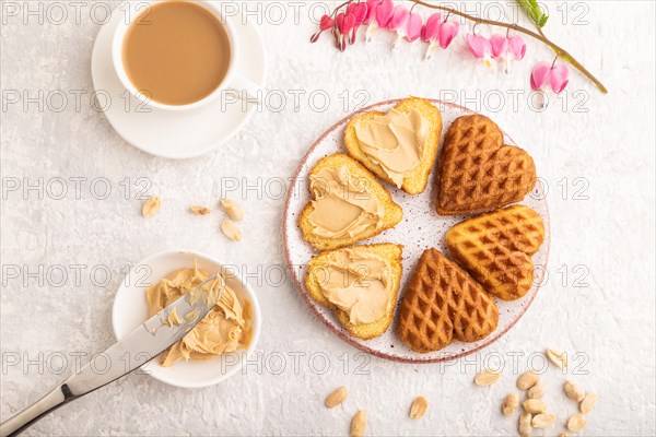 Homemade waffle with peanut butter and cup of coffee on a gray concrete background. top view, flat lay, close up