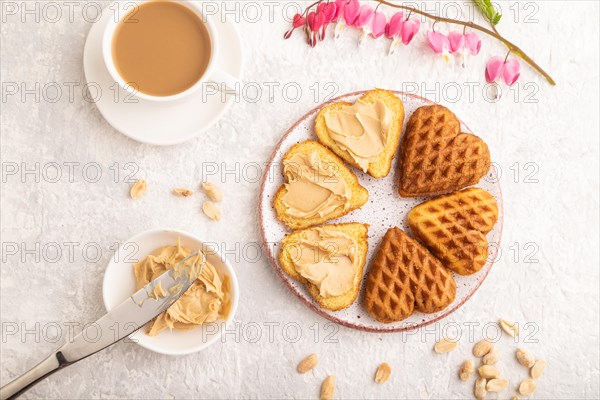Homemade waffle with peanut butter and cup of coffee on a gray concrete background. top view, flat lay, close up