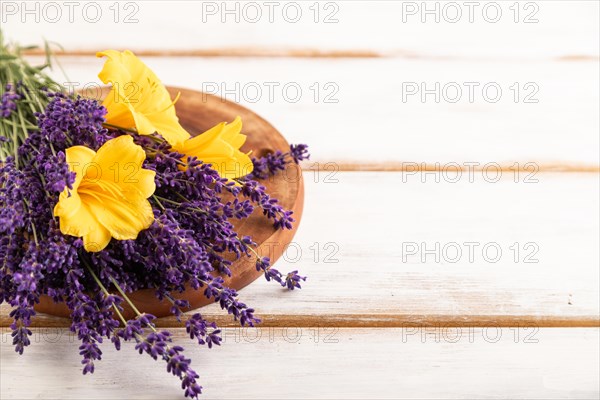 Beautiful day lily and lavender flowers on white wooden background, side view, close up, selective focus