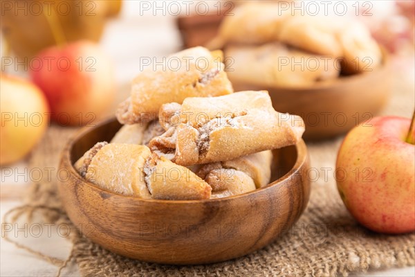 Homemade sweet cookie with apple jam and cup of coffee on white wooden background and linen textile. side view, close up, selective focus