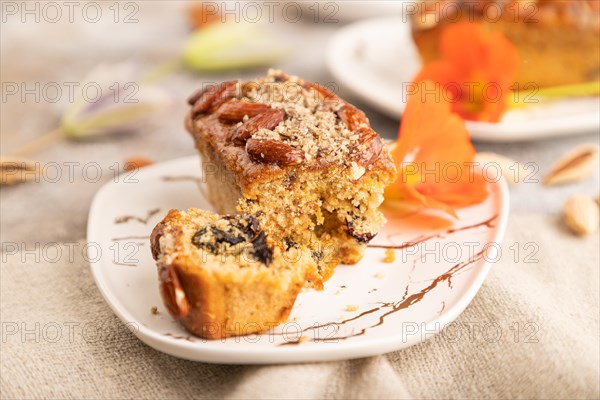 Caramel and almond cake with cup of coffee on brown concrete background and linen textile. side view, close up, selective focus