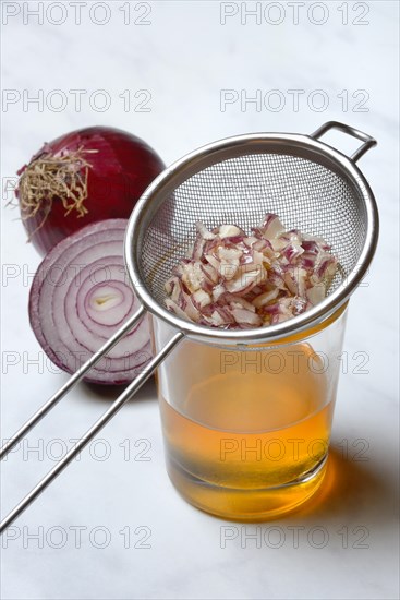 Honey in a jar and chopped onion as ingredients for cough syrup, sieve