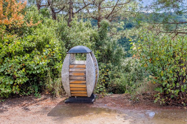 Wood and concrete trash can on hiking trail in nature park in Istanbul, Tuerkiye