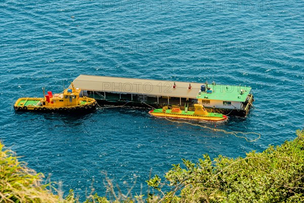 Tourist submarine and tug boat moored to floating dock in South Korea