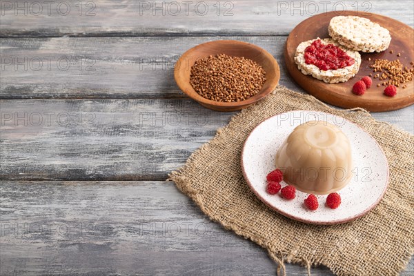 Buckwheat milk jelly on gray wooden background and linen textile. side view, copy space