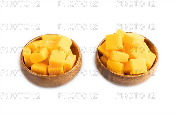 Dried and candied mango cubes in wooden bowls isolated on white background. Side view, close up, vegan, vegetarian food concept