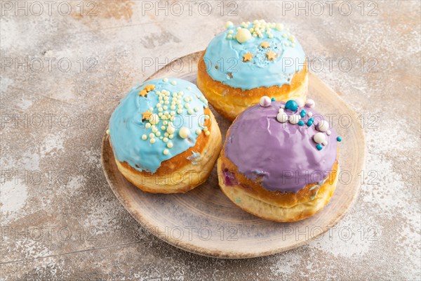 Purple and blue glazed donut on brown concrete background. side view, close up. Breakfast, morning, concept