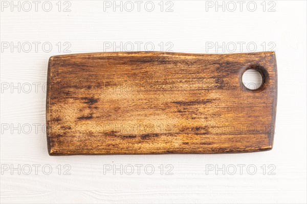 Empty rectangular wooden cutting board on white wooden background. Top view, close up, flat lay
