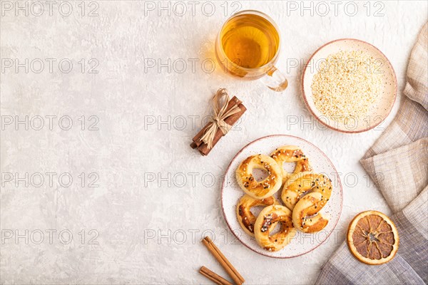 Homemade asian salted cookies, cup of green tea on gray concrete background and linen textile. top view, flat lay, copy space
