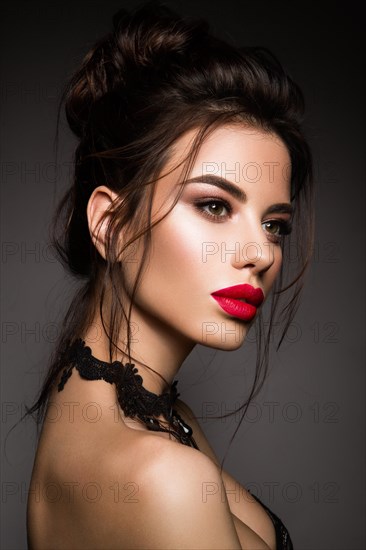 Gorgeous Young Brunette Woman face portrait. Beauty Model Girl with bright eyebrows, perfect make-up, red lips, touching her face. Sexy lady makeup for party