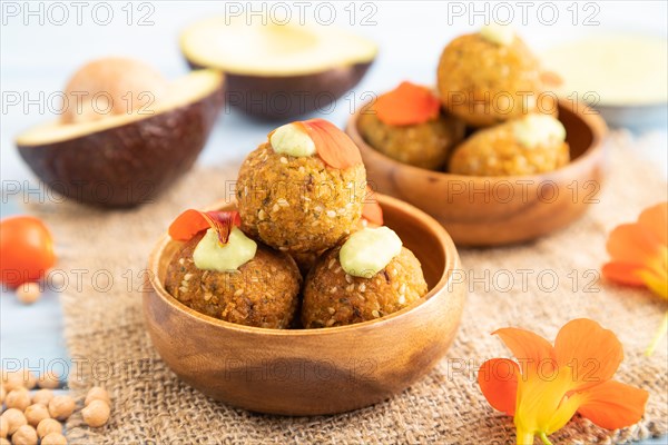 Falafel with guacamole on blue wooden background and linen textile. Side view, close up, selective focus