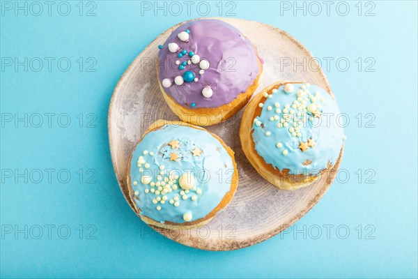 Purple and blue glazed donut on blue pastel background. top view, flat lay. Breakfast, morning, concept