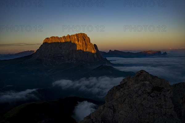 Sunrise over a sea of fog with the peaks of the Sella massif in the background, Corvara, Dolomites, Italy, Europe