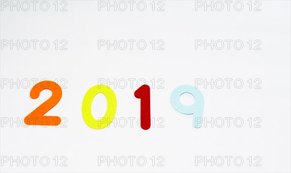 The numbers 2019 made of felt of different colors photographed on white background