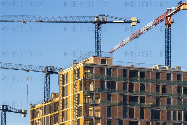 Construction cranes on a facade of an apartment building in the Poblenou neighborhood in the city of Barcelona