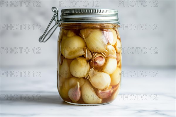 A closed preserving jar full of pickled garlic cloves and shallots on a marble surface, AI generated, AI generated