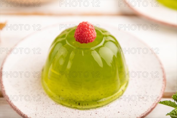 Mint and raspberry green jelly on white wooden background. side view, close up, selective focus