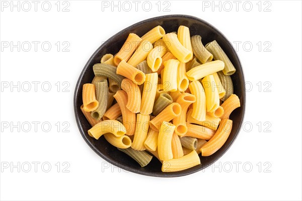 Rigatoni colored raw pasta in bowl isolated on white background. Top view, flat lay