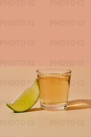 Tequila shot with lime under hard sunlight