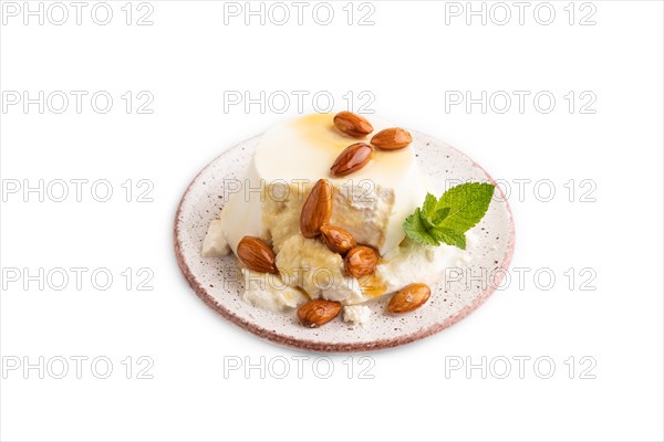 Ricotta cheese with honey and almonds isolated on white background. side view, close up