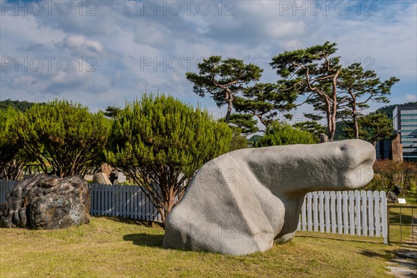 Large white boulder in natural shaped looks like phallus in public park in South Korea