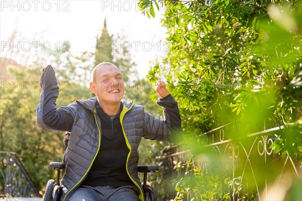 Disabled man in wheelchair enjoying life and nature in a park