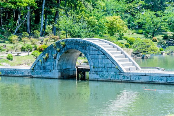 Concrete bridge over man made lake in Shukkeien gardens in Hiroshima, Japan, Asia