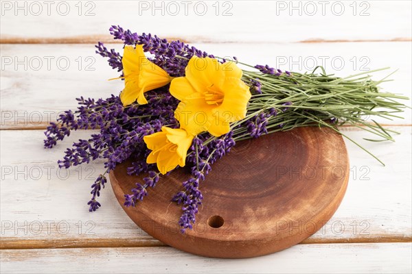 Beautiful day lily and lavender flowers on white wooden background, side view, close up