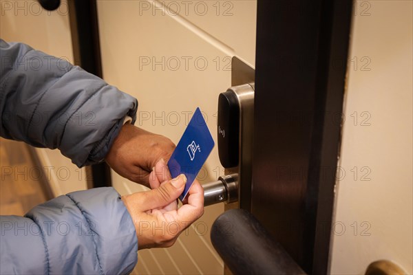 Woman hand using electronic smart key card to unlock door in hotel or house. Digital lock, door access control, contactless concept. Closeup, copy space