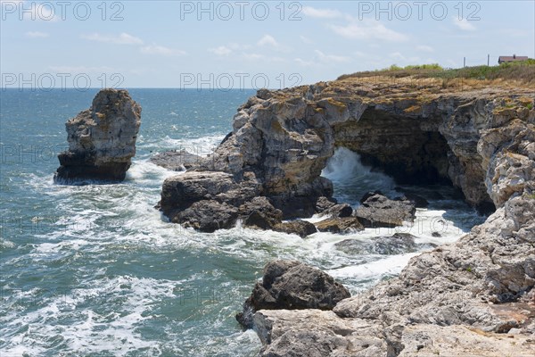 Rocky coastal landscape with a natural arch over a roaring sea under a clear blue sky, rock arch, stone arch, Tyulenovo, Tyulenovo, Shabla, Dobrich, Black Sea, Bulgaria, Europe