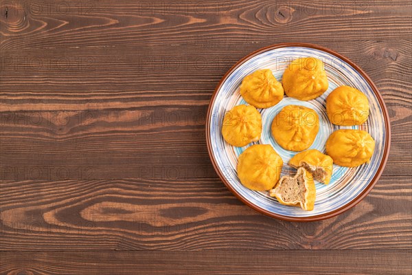 Fried manti dumplings on brown wooden background. Top view, flat lay, copy space