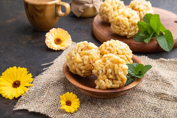 Traditional Tatar candy chak-chak made of dough and honey with cup of coffee on a black concrete background and linen textile. Side view, close up