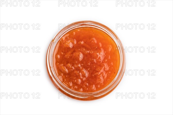 Carrot jam with cinnamon in glass jar isolated on white background. Top view, flat lay, close up