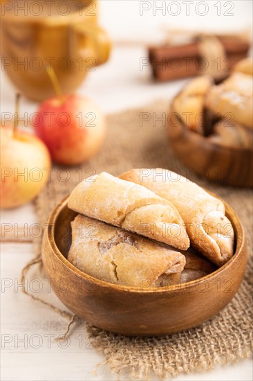 Homemade sweet cookie with apple jam and cup of coffee on white wooden background and linen textile. side view, close up, selective focus