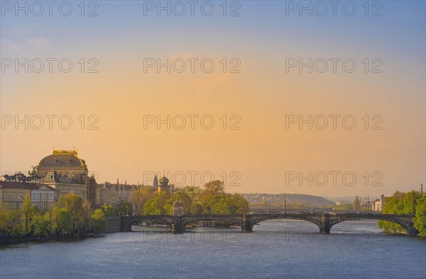 Beautiful National Theatre building and bridges over Vltava river in the city center of Prague, Czech Republic (Czechia), at sunrise