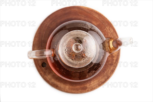 Red tea with herbs in glass teapot isolated on white background. Healthy drink concept. Top view, flat lay, close up