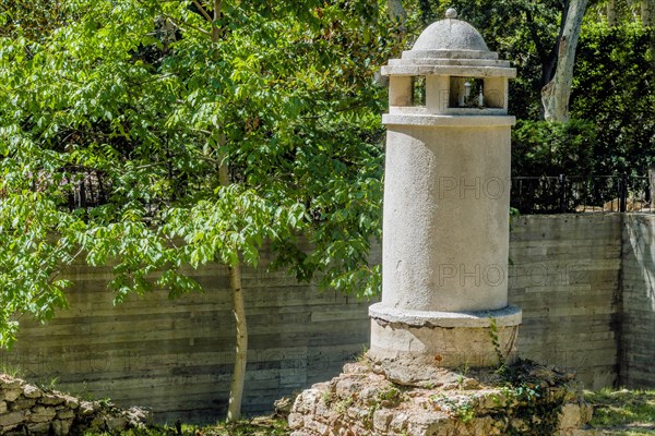 Remains of small concrete tower with dome in public park on sunny afternoon in Istanbul, Tuerkiye