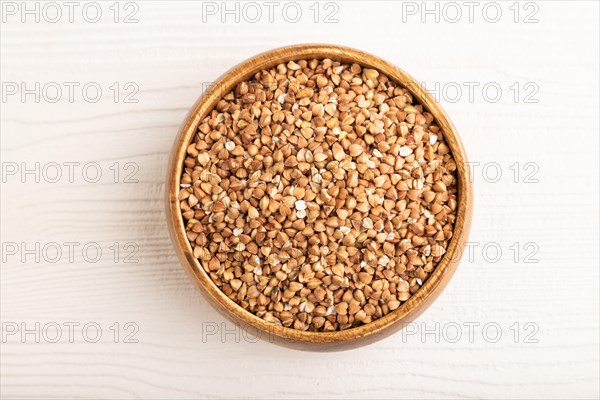 Raw buckwheat on white wooden background. Top view, close up