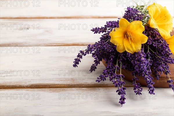 Beautiful day lily and lavender flowers on white wooden background, side view, copy space