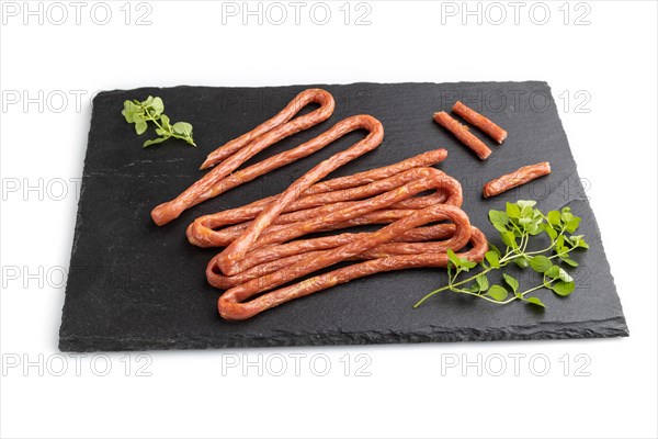 Traditional polish smoked pork sausage kabanos on a slate cutting board isolated on white background. Side view, close up