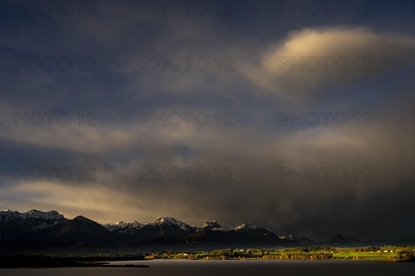 Lake Hopfensee with stormy sky in soft morning light and Allgaeu mountains in the background, Hopfen am See, Ostallgaeu, Swabia, Bavaria, Germany, Europe