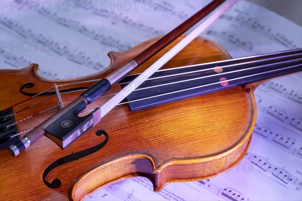 Viola with bow and music book in front of a monochrome background, studio photograph, Germany, Europe