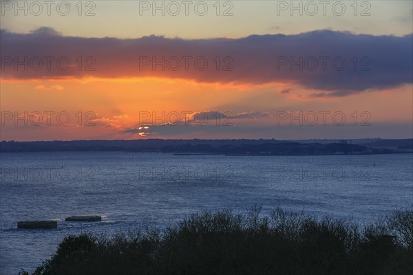 View at sunset from the Pointe de l'Armorique over the bay Rade de Brest, in the background the peninsula Presqu'ile de Crozon with the Ile Longue, base strategic nuclear submarines of the French Navy, on the left the two dolphins built by the German Navy during the Second World War, where the battleship Bismarck was supposed to dock, peninsula Plougastel-Daoulas, department Finistere Penn-ar-Bed, region Bretagne Breizh, France, Europe
