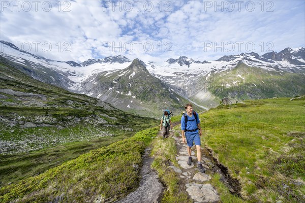 Two mountaineers on a hiking trail in a picturesque mountain landscape, mountain peaks with snow and glacier Hornkees and Waxeggkees, summit Grosser Moeseler and Hornspitzen, Berliner Hoehenweg, Zillertal Alps, Tyrol, Austria, Europe