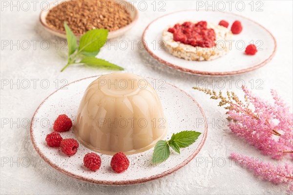 Buckwheat milk jelly on gray concrete background. side view