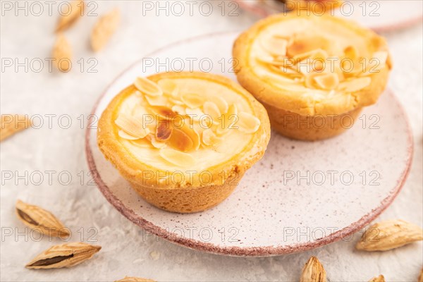 Traditional portuguese cakes pasteis de nata, custard small pies with almonds with cup of coffee on gray concrete background. Side view, close up, selective focus