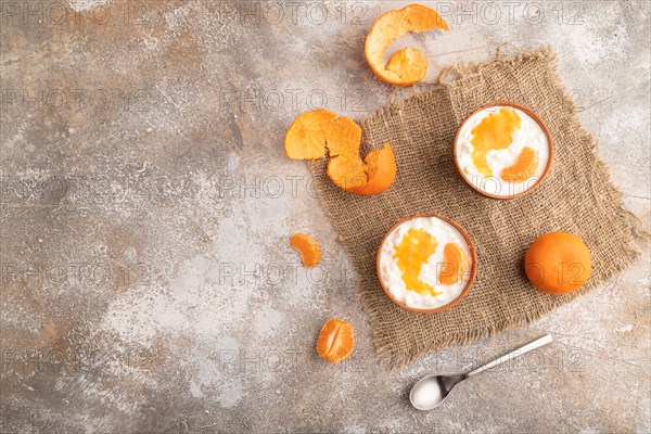Grained cottage cheese with tangerine jam on brown concrete background and linen textile. top view, flat lay, copy space