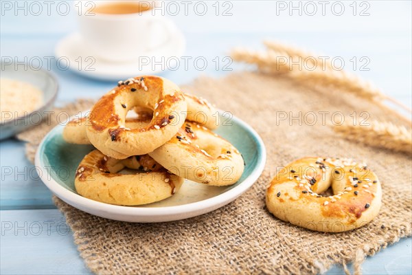 Homemade asian salted cookies, cup of green tea on blue wooden background and linen textile. side view, close up, selective focus