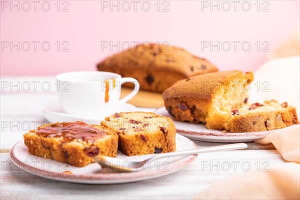 Homemade cake with raisins, almonds, soft caramel on a white and pink background. Side view, close up, selective focus